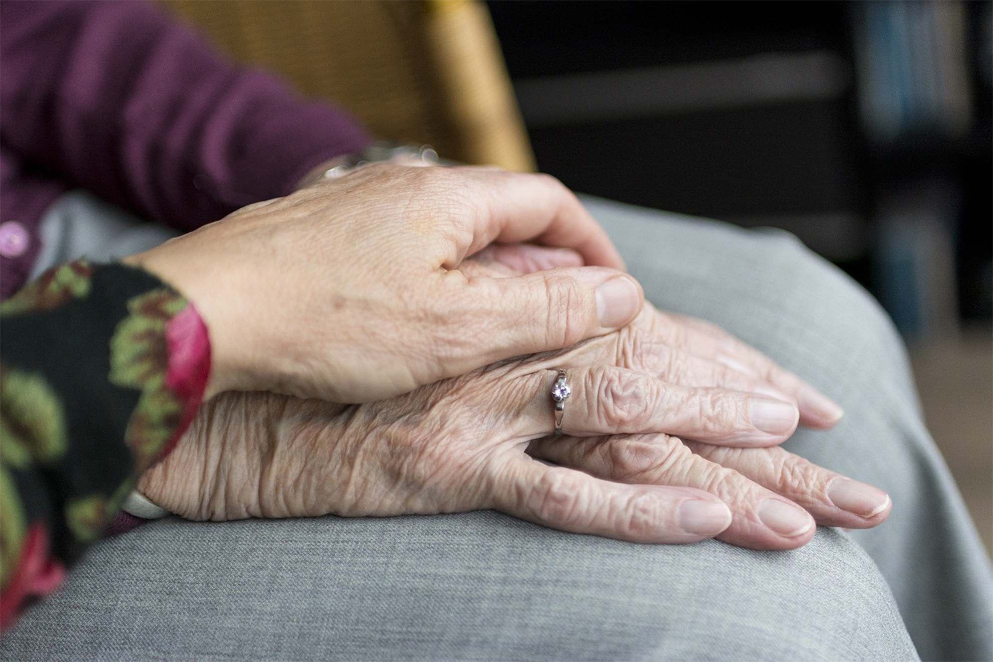 A young hand on top of an older hand