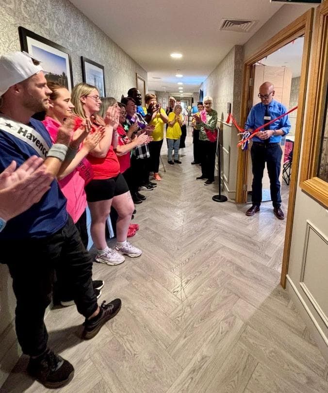 director-cutting-ribbon-with-staff-watching