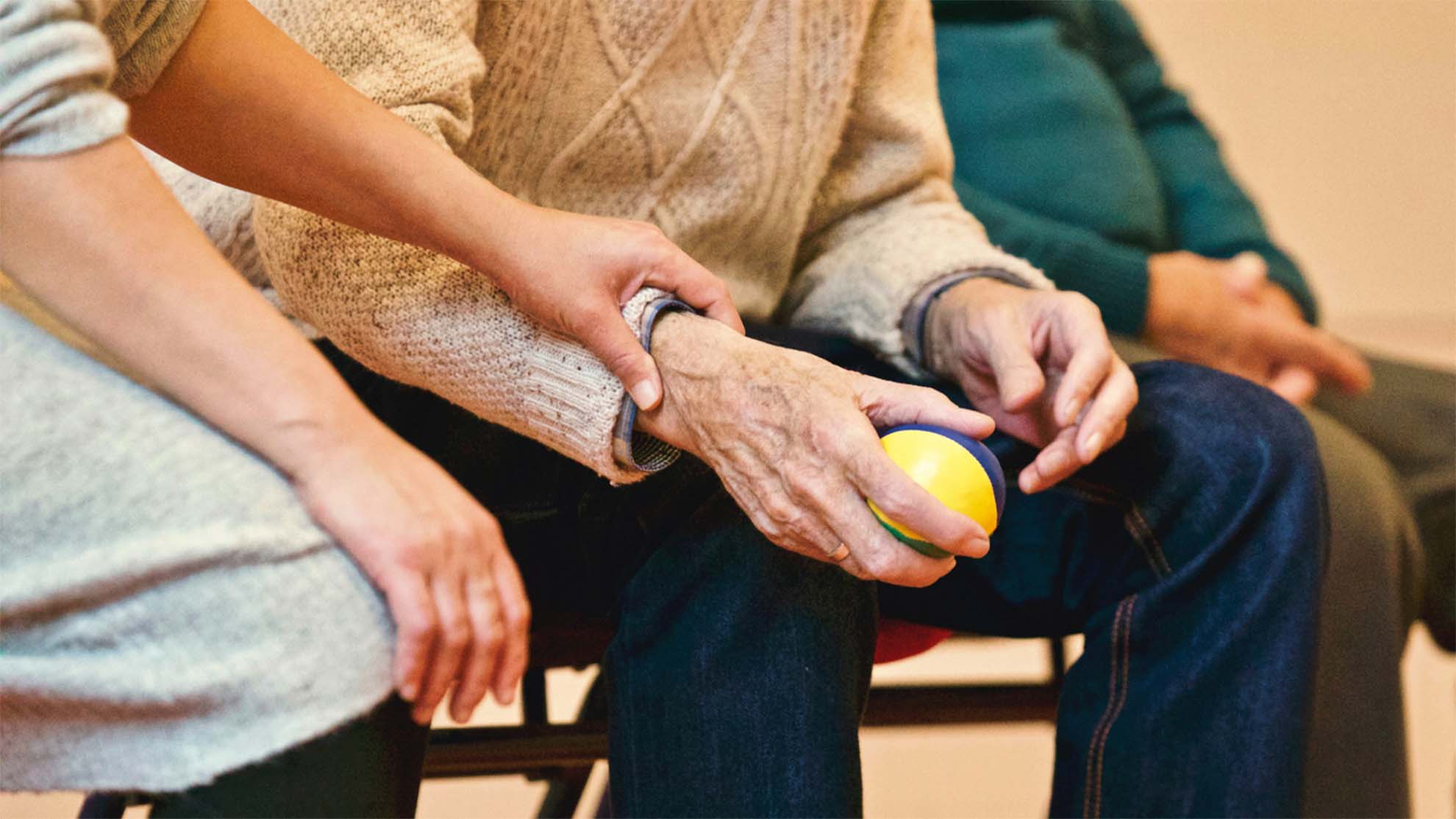 A resident holding a blue and yellow ball