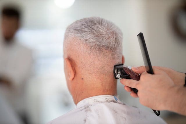 older man getting hair cut from the back