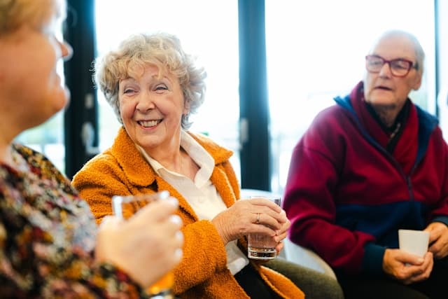 elderly woman laughing with a cup of tea