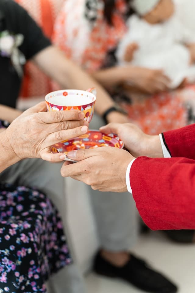 elderly person receiving a cup of tea